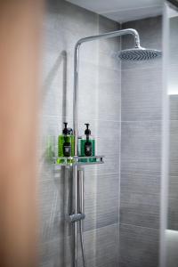 a shower with two shampoo bottles on a shelf in a bathroom at Terra Kotta 2 in Vrachos