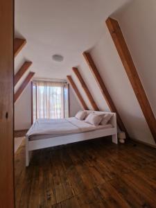 a bedroom with a white bed in a attic at Green Eye in Žabljak