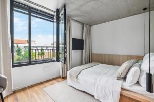 a bedroom with a bed and a large window at Habyt-The Waterfront in Berlin