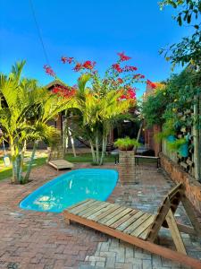 a swimming pool with a bench and a table and trees at Casa ecológica temporada in Olímpia