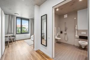 a bathroom with a shower and a toilet and a sink at Habyt-The Waterfront in Berlin