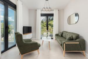 a living room with a couch and chairs and a tv at NM Palace Apartment in Kotor