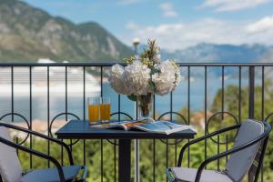a table with a vase of flowers on a balcony at NM Palace Apartment in Kotor