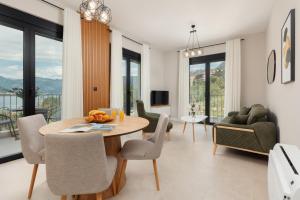 a living room with a dining room table and chairs at NM Palace Apartment in Kotor
