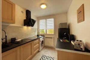 a small kitchen with a sink and a stove at Rouen Port de plaisance et MIN - Appart lumineux in Rouen +6 photos