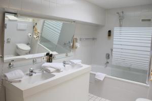 a bathroom with a sink and a toilet and a mirror at Hotel Astoria am Urachplatz in Stuttgart