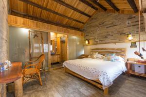a bedroom with a bed and a desk and a table at Governor's Mansion in Yangshuo