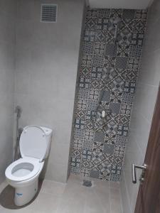 a bathroom with a toilet and a mosaic tile floor at Appartement Miftah Sahill 1 haut Standing in Agadir +23 photos