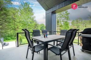 a table and chairs on a patio with a grill at The Green Chill at Cité-Jardin - Private SPA, Ping pong, Fireplace & Pool in Saint-Basile