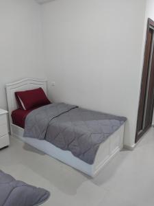 a bedroom with a bed with a red pillow at Appartement Miftah Sahill 1 haut Standing in Agadir