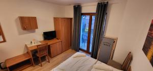 a room with a bed and a desk with a computer at Pensjonat Senya in Niechorze