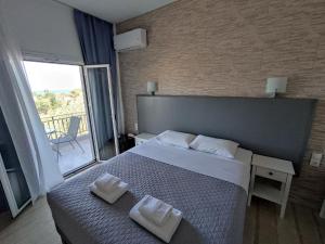 una camera da letto con un letto con due asciugamani sopra di Tina Hotel a Dassia