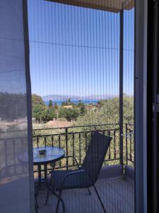 un tavolo e una sedia sul balcone con vista di Tina Hotel a Dassia