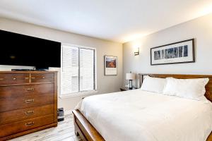 a bedroom with a bed and a dresser with a flat screen tv at Elegant Escape in Park City +26 photos