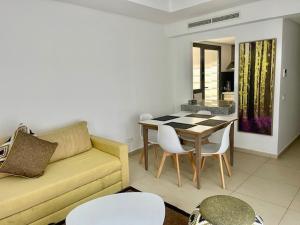 a living room with a couch and a table and chairs at Appartement LUXUEUX 1 plage SFIHA AL HOCEIMA in Ajdir