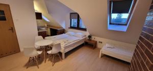 a small room with a bed and a table and chairs at Pensjonat Senya in Niechorze