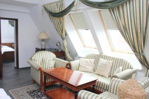 a living room with two chairs and a table at Hotel Astoria am Urachplatz in Stuttgart