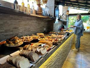 a woman standing in front of a buffet of food at Pousada Desfiladeiro da Serra in Serra Negra