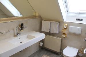 a bathroom with a sink and a toilet and a window at Hotel Astoria am Urachplatz in Stuttgart