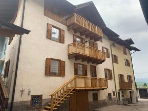 a building with wooden balconies and stairs on it at Casa Frasnelli Cunevo in Cunevo