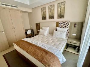 a bedroom with a large bed and two windows at Appartement LUXUEUX 1 plage SFIHA AL HOCEIMA in Ajdir