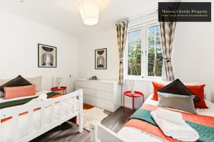 a bedroom with two beds and a window at Dollis Valley 3Bedroom House Sleeps 8 in London With FREE PARKING By Maison Christo Property Short Lets & Serviced Accommodation in Barnet