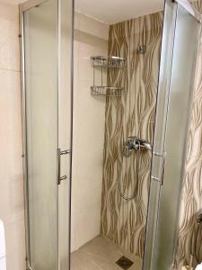 a shower with a glass door in a bathroom at Backyard houses in Toroni +35 photos