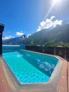 a swimming pool with mountains in the background at Park Hotel Suisse & Spa in Chamonix-Mont-Blanc