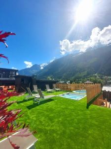 a green lawn with a view of a mountain at Park Hotel Suisse & Spa in Chamonix-Mont-Blanc