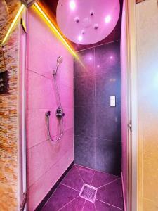 a pink bathroom with a shower with a purple ceiling at Park Hotel Suisse & Spa in Chamonix-Mont-Blanc