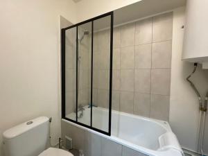 a bathroom with a tub and a toilet and a shower at Rouen Centre - Joli studio avec espace extérieur in Rouen