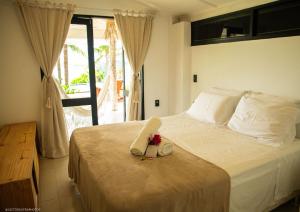 una camera da letto con un letto e un asciugamano sopra di Pipa Sunset Home a Pipa Altre 25 foto