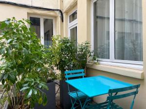 a blue table and chairs in front of a window at Rouen Centre - Joli studio avec espace extérieur in Rouen