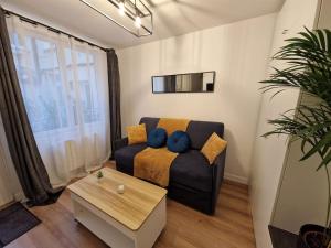 a living room with a couch and a table at Rouen Centre - Joli studio avec espace extérieur in Rouen