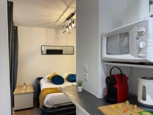 a small room with a bed and a tv at Rouen Centre - Joli studio avec espace extérieur in Rouen +8 photos