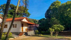 a house with palm trees in front of it at Pousada Serra do Cipó in Serra do Cipo