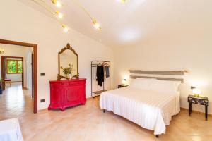 a bedroom with a bed with a red dresser and a mirror at Villa Calma con idromassaggio e giardino vicino Saturnia in Montemerano +42 photos