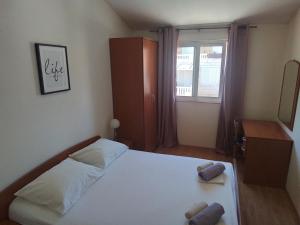 a bedroom with a bed with two pillows on it at Apartmani Fani 2 min walking from sea in Orebić