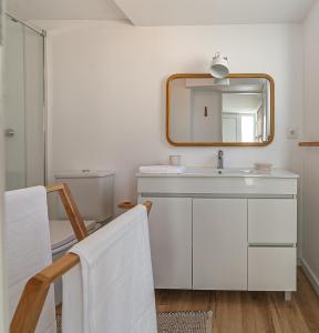 ein Badezimmer mit Waschbecken und Spiegel in der Unterkunft Villa Mau Maria incl Parking by Home Sweet Home Aveiro in Aveiro + 79 Fotos