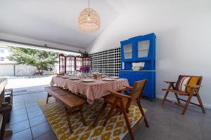 ein Esszimmer mit einem Tisch und Stühlen sowie einem blauen Schrank in der Unterkunft Villa Mau Maria incl Parking by Home Sweet Home Aveiro in Aveiro