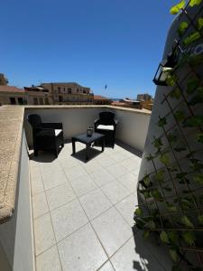 un patio con sedie e un tavolo sul tetto di Amunì in terrazza a Porto Empedocle