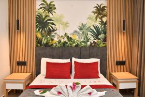 1 dormitorio con 1 cama con almohadas y toallas rojas en Gürol Apart, en Fethiye