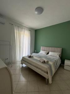 una camera da letto con un letto grande con una parete verde di Amunì in terrazza a Porto Empedocle