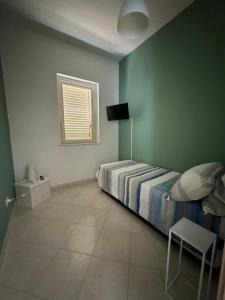 una camera da letto con un letto, una sedia e una finestra di Amunì in terrazza a Porto Empedocle