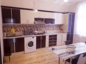 a kitchen with a washing machine and a table at Qafqaz White Palace in Gabala