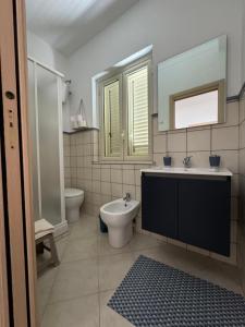 un bagno con lavandino, water e specchio di Amunì in terrazza a Porto Empedocle