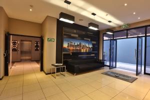 a large living room with a couch and a tv at Inani Hotel Morning Star in Pretoria