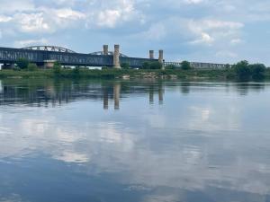 a train on a bridge over a body of water at Apartament Bello in Rokitki +1 photo