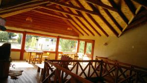 une grande terrasse couverte avec un toit en bois, des tables et des chaises dans l'établissement Complejo Turístico Sol de Puelo, à Lago Puelo