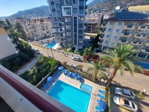 an apartment with a swimming pool and palm trees and buildings at Amber-Rose Apart Hotel in Alanya